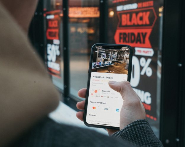 a person holding a phone checking out black friday deals
