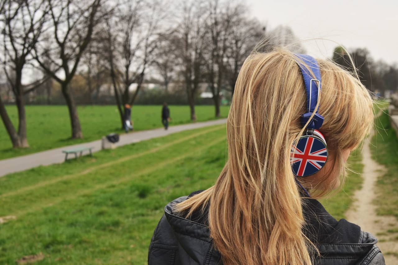 young lady UK headphones in park