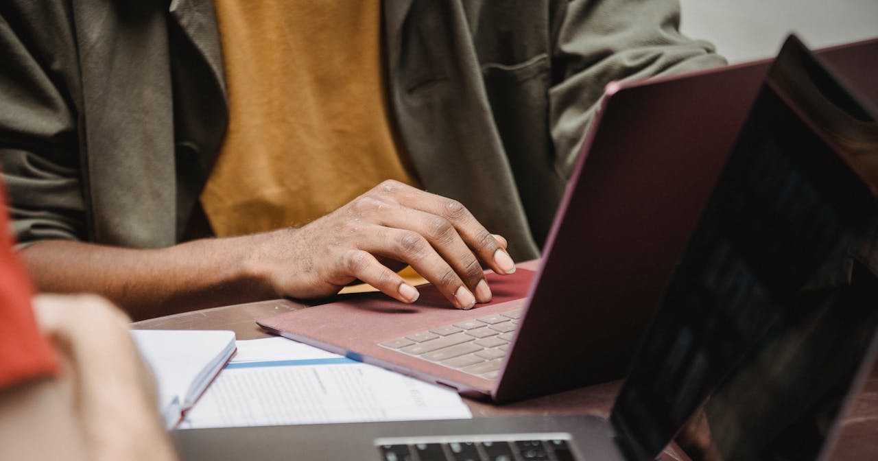 Male colleagues perform conversion funnel analysis on laptops in a marketing agency office.