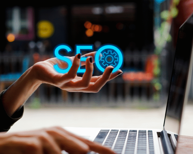 SEO text in left hand facing a laptop